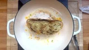 Grilled cheese sandwich in a pan, toasted to perfection with melted cheese. Ideal comfort food cooking scene.