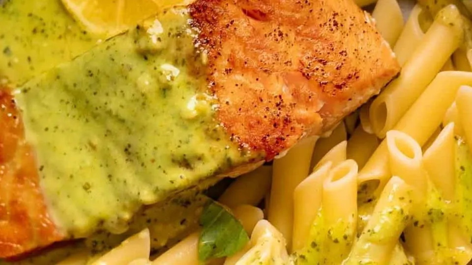 Grilled salmon with lemon herb sauce served with penne pasta.