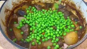 Homemade beef stew with potatoes and peas in a pot, perfect for a hearty and comforting meal.