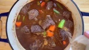 Hearty beef stew with carrots and celery in a pot, perfect comfort food for chilly days.