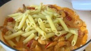 Delicious penne pasta with shrimp and cherry tomatoes in creamy sauce. Perfect for Italian seafood lovers.