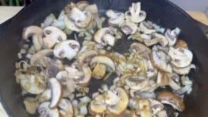 Sautéed mushrooms and onions in a cast iron skillet, perfect for a flavorful side dish or meal ingredient.