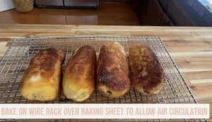 Golden-brown baked items cooling on a wire rack for optimal air circulation in a kitchen setting.