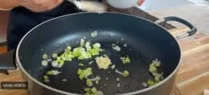 Cooking onions and garlic in a frying pan for a delicious stir-fry recipe.