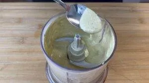 Creamy sauce in a blender with a spoon scooping it out. Perfect for dips and dressings.