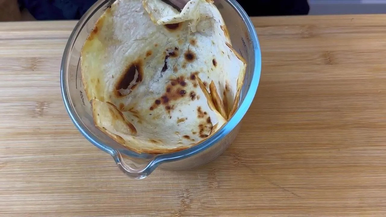 Toasted tortilla in a glass bowl on a wooden surface, perfect for wraps or dipping.