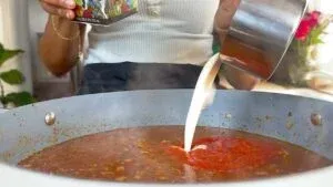 Pouring cream into a steaming pot.