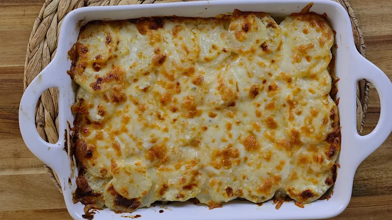 Creamy baked cheese potato casserole in a white dish.