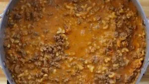 Close-up of homemade beef macaroni in a pot, featuring ground beef, pasta.