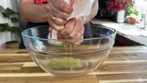 Person squeezing liquid out using a cheese cloth.