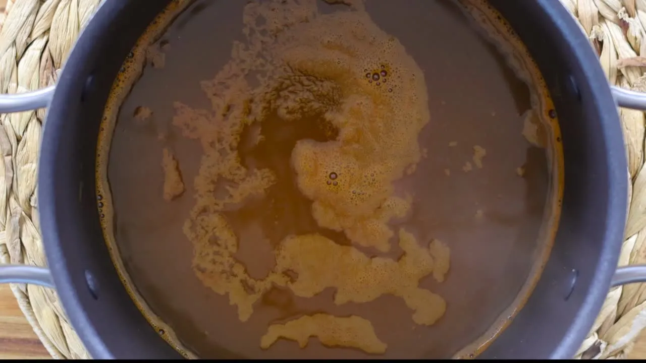 A pot of rich brown broth simmering.