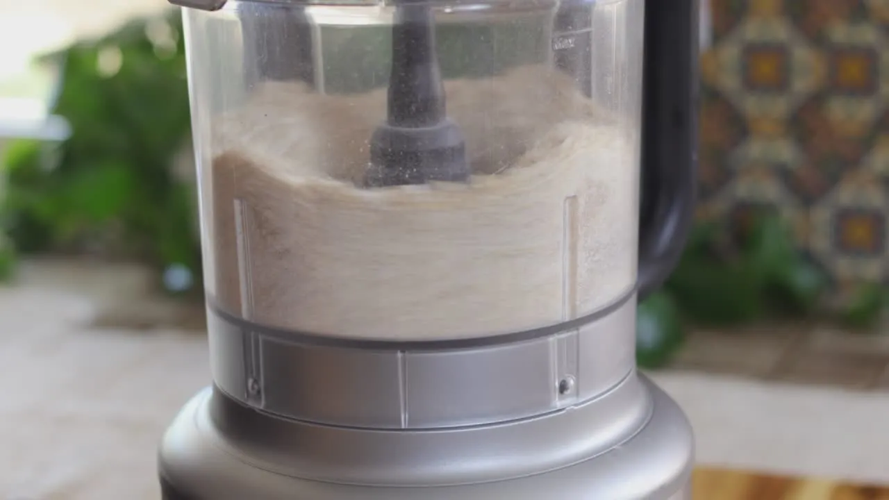 Food processor blending ingredients on kitchen counter.