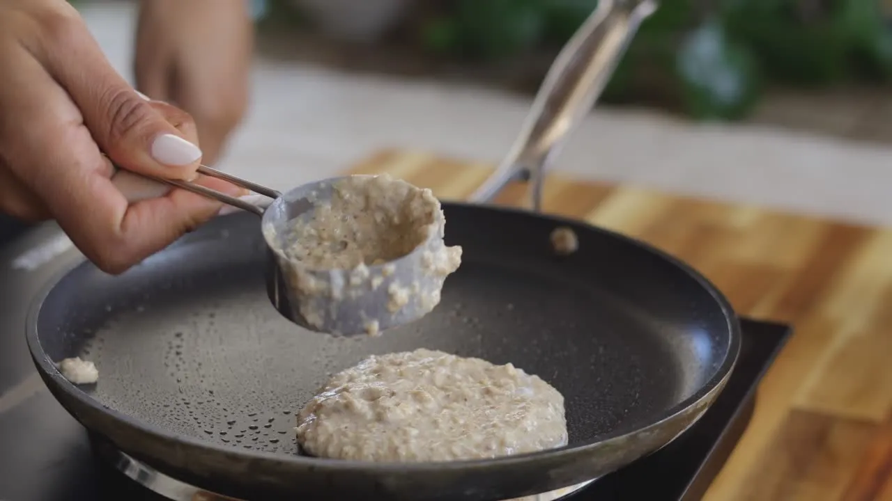 Pouring pancake batter onto a hot skillet.