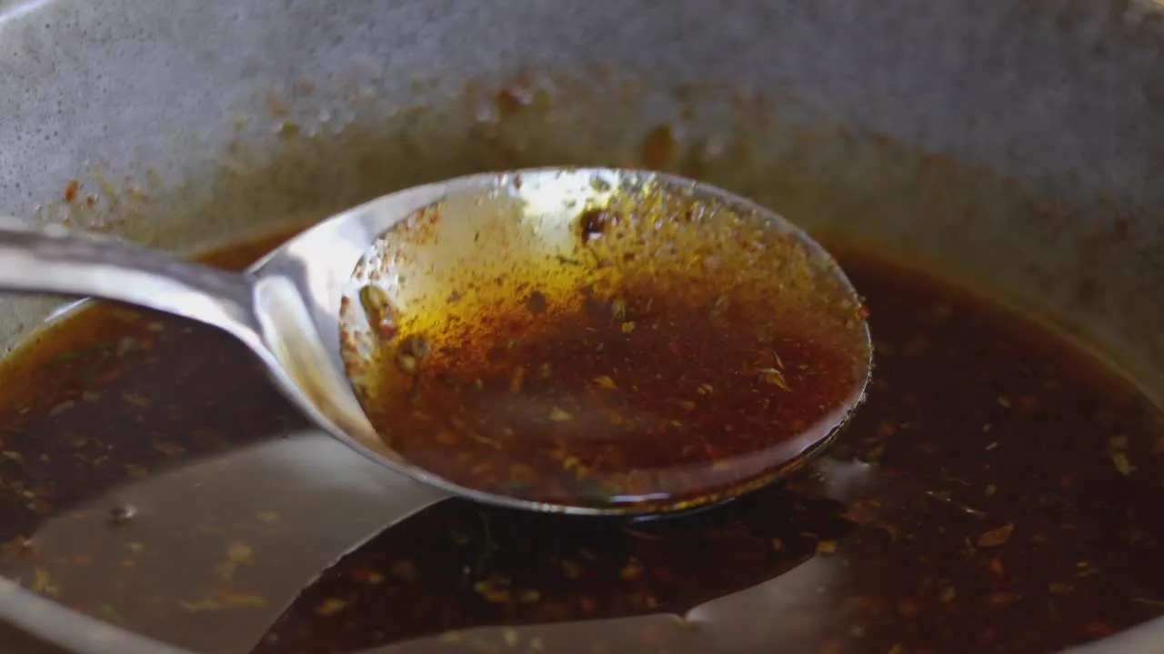 Close-up of a spoon lifting an herby olive oil dressing