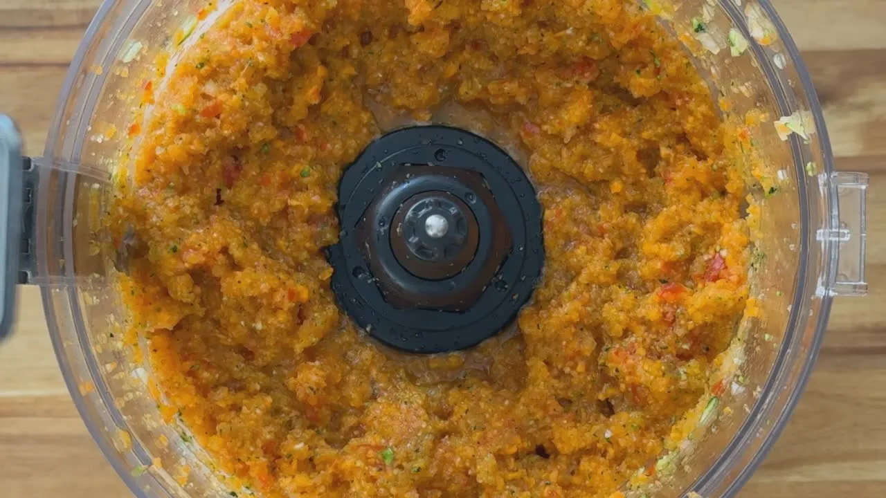 Close-up of finely chopped vegetables in a food processor.