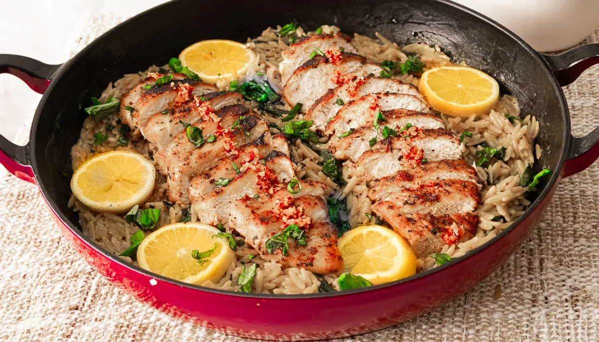 Lemon chicken orzo pasta in a cast iron skillet.