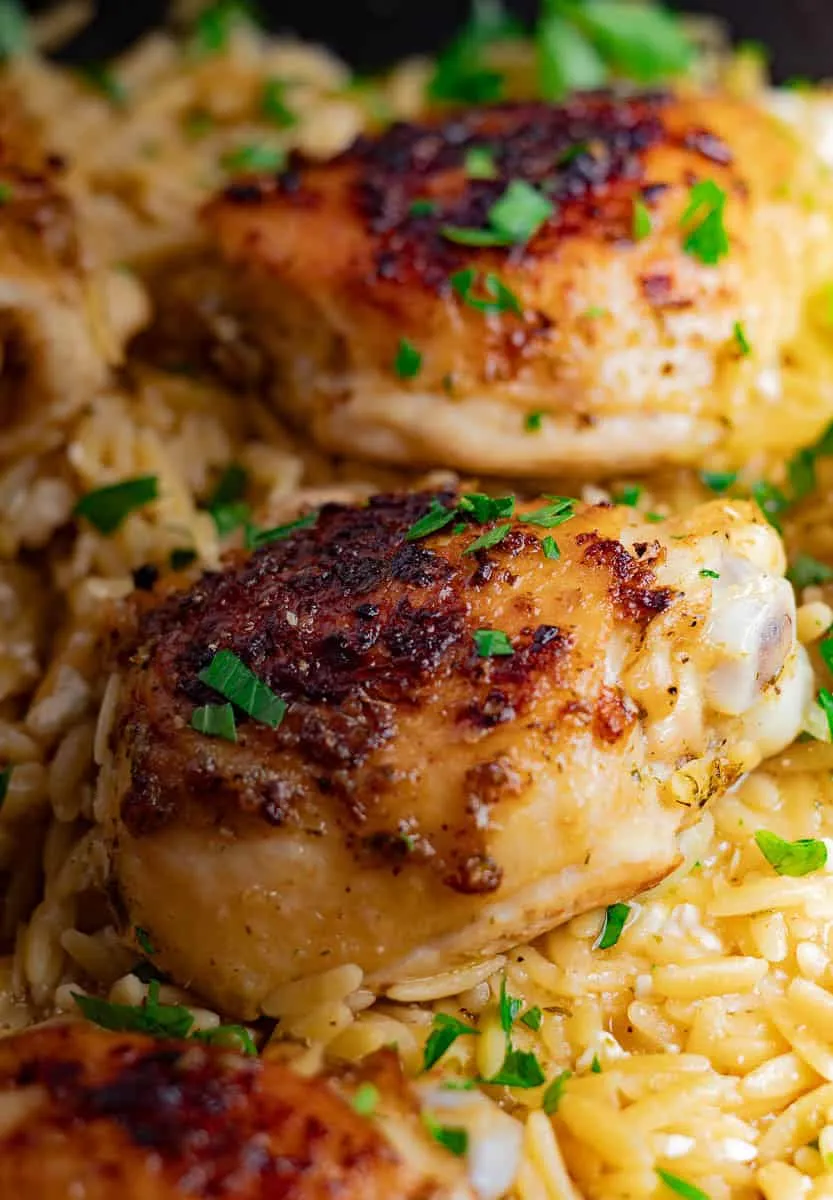 Greek Chicken Orzo Bake garnished with fresh parsley.