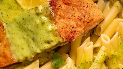 Grilled salmon with lemon herb sauce served with penne pasta.