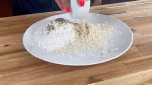 Mixing seasoning with flour and grated cheese on a plate for breading, ready to prepare a delicious dish.