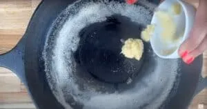 Adding butter to a hot skillet for cooking.