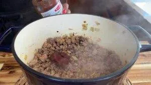 Cooking ground meat with onions and tomato paste in a pot.