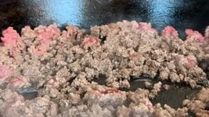 Cooking ground beef on a hot skillet for a delicious meal preparation.