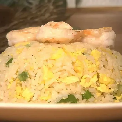 Delicious shrimp fried rice with eggs and green onions on a plate, perfect for a tasty Asian-inspired meal.