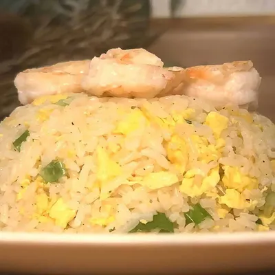 Delicious shrimp fried rice with eggs and green onions on a plate, perfect for a tasty Asian-inspired meal.