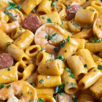 Creamy prawn and chorizo pasta garnished with fresh herbs.
