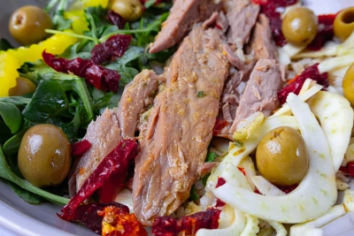Fresh salad with tuna, olives, arugula, fennel, and sun-dried tomatoes.