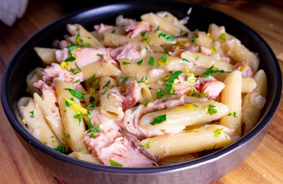 Creamy pasta alla Salmone in a black bowl garnished with parsley.