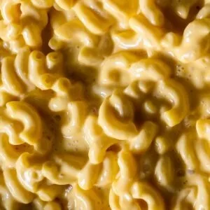 Creamy macaroni and cheese with rich, gooey cheddar sauce, capturing the classic comfort food close-up.