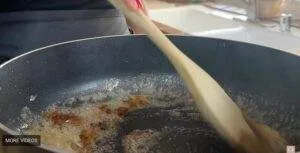 Stirring caramelized sugar in a pan with a wooden spoon for a delicious homemade dessert recipe.